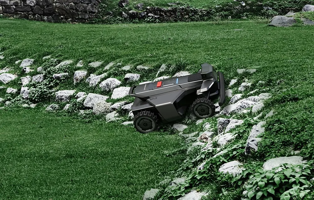 Robots pļāvējs kāpj pa akmeņainu nogāzi