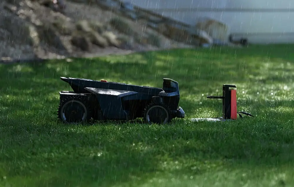 Robots pļāvējs atgriežas uzlādes stacijā lietus laikā