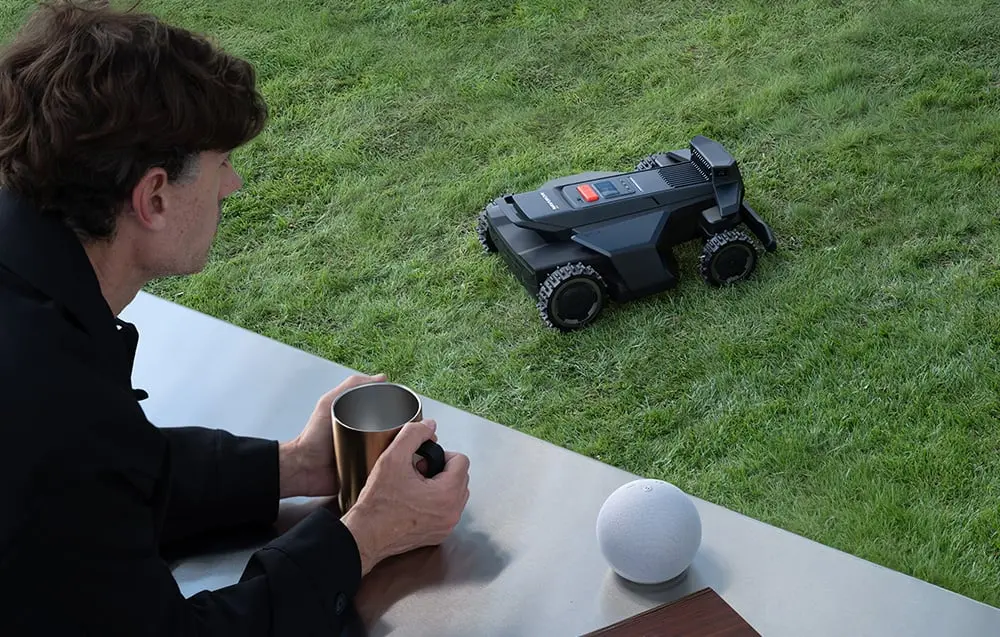 Lietotājs kontrolē robotu pļāvēju ar viedtālruni